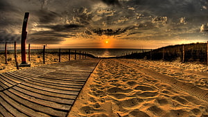 Sunset Over Wooden Boardwalk Leading To Ocean Beach With Dramatic Clouds HD wallpaper