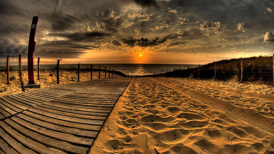 Sunset Over Wooden Boardwalk Leading To Ocean Beach With Dramatic Clouds HD wallpaper