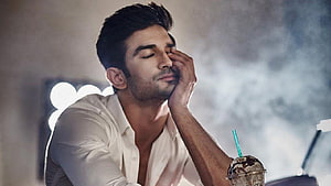 Sushant Singh Rajput in a white shirt with a thoughtful expression and iced coffee HD wallpaper