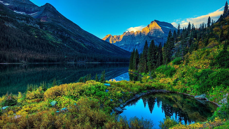 Serene Mountain Lake with Golden Peak Reflection and Lush Forested Hills HD wallpaper