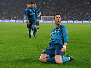 Cristiano Ronaldo kneeling on the pitch in a Real Madrid kit during a Champions League match HD wallpaper
