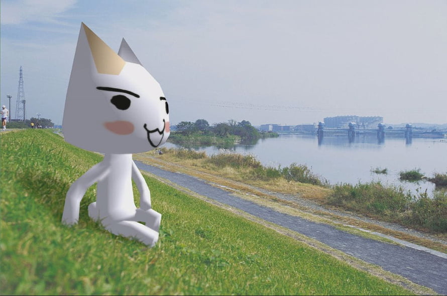Monokuma from Danganronpa sitting on grass by a river path HD wallpaper