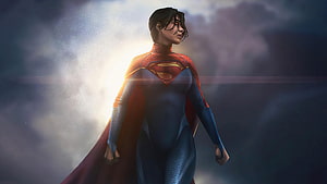 Supergirl in Blue Suit and Red Cape Standing in Dramatic Clouds HD wallpaper