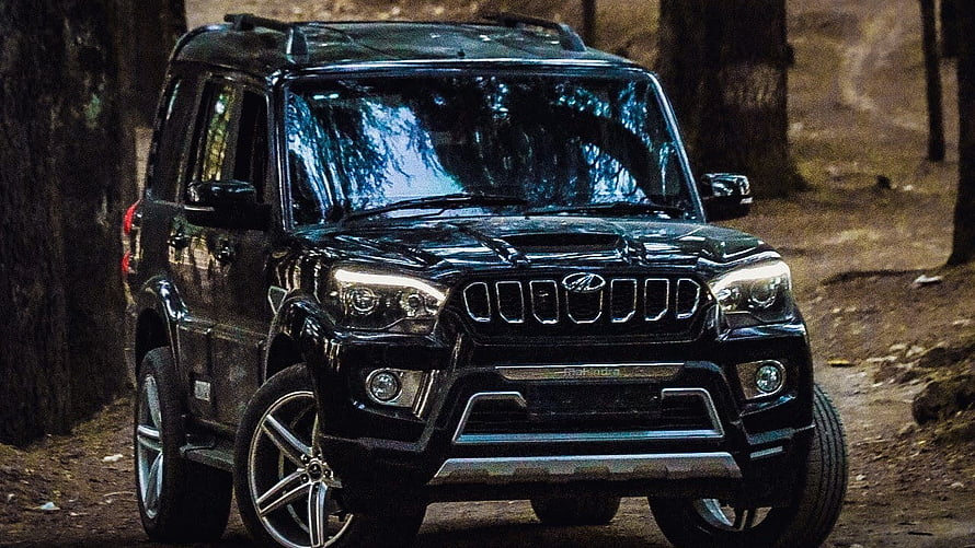Black Mahindra Thar SUV parked on a dirt road in a forest with headlights on HD wallpaper