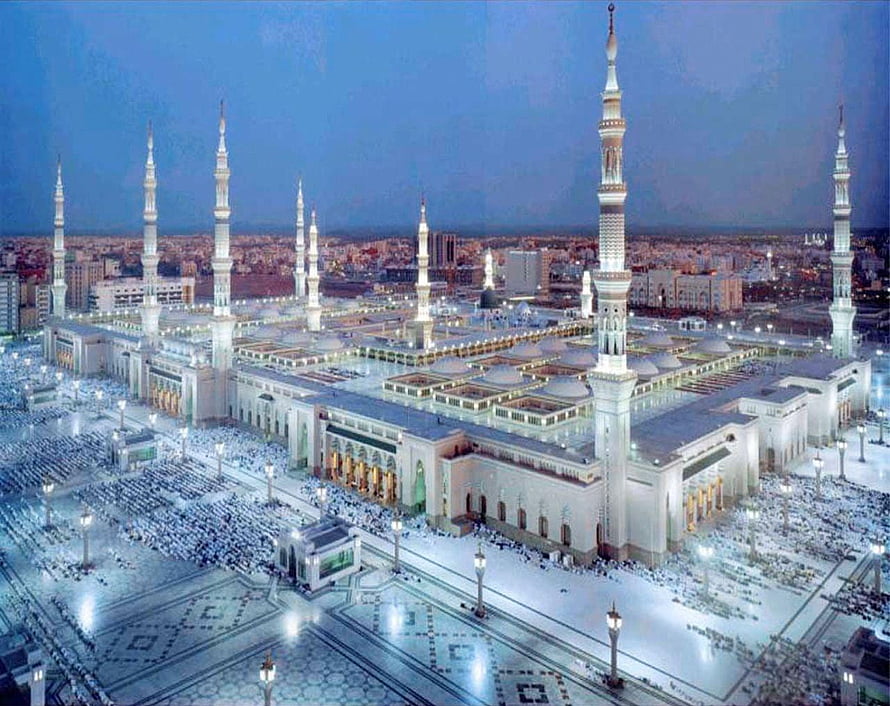 Al-Masjid an-Nabawi in Medina at Night with Illuminated Minarets and Crowds HD wallpaper