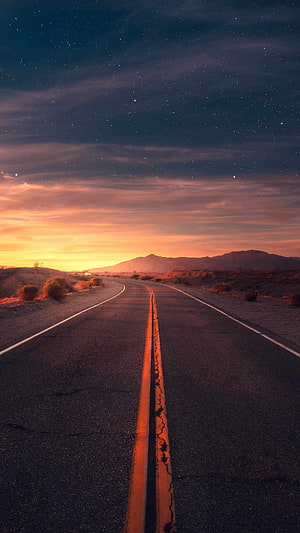 Desert Highway at Dawn Under a Starry Sky with Distant Mountains HD phone wallpaper