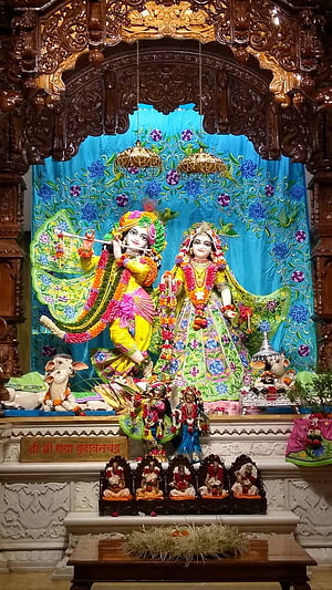 Radha Krishna Temple Altar with Intricate Wooden Carvings and Floral Decorations HD phone wallpaper
