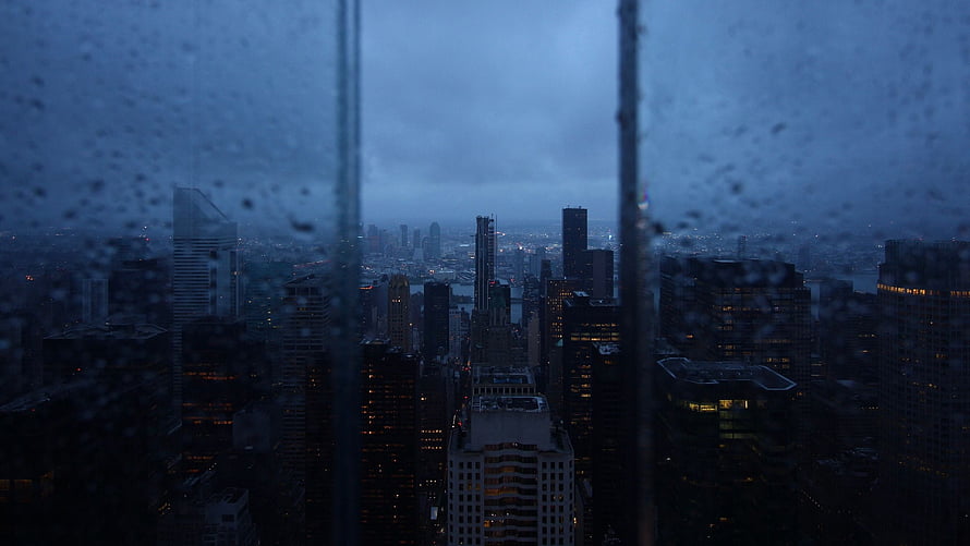 Moody Cityscape View Through Rain-Streaked Window at Dusk HD wallpaper