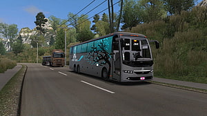 Grey coach bus with blue tree livery driving on a scenic mountain road in a realistic simulation game HD wallpaper