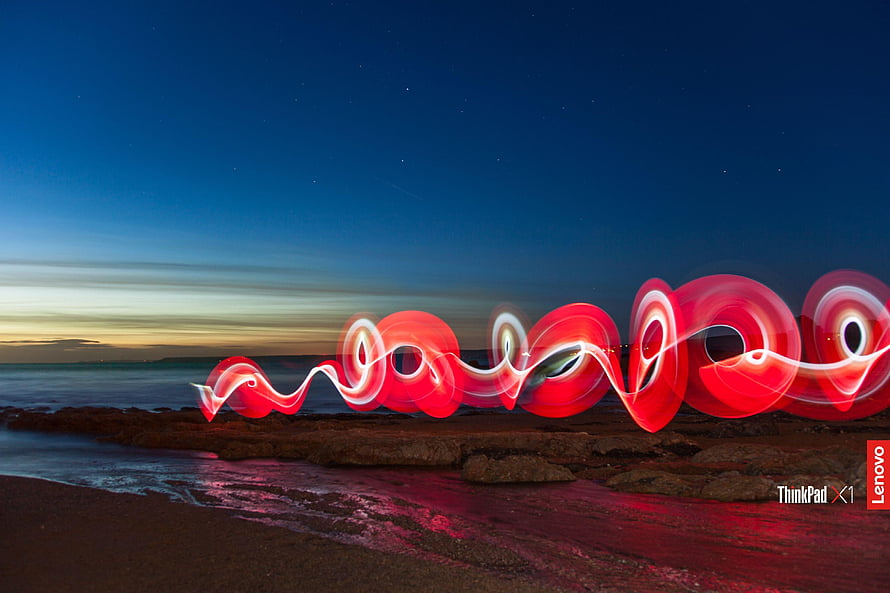 Red Light Painting Spirals on Rocky Beach at Night HD wallpaper