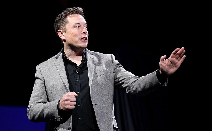 Elon Musk Speaking on Stage in Grey Blazer and Black Shirt HD wallpaper