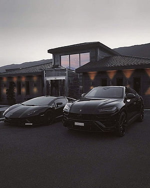 Two Black Lamborghini Supercars Parked in Front of a Modern Luxury Residence at Dusk HD phone wallpaper