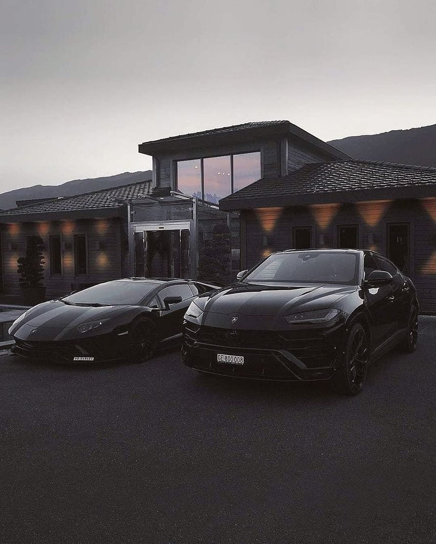 Two Black Lamborghini Supercars Parked in Front of a Modern Luxury Residence at Dusk HD phone wallpaper