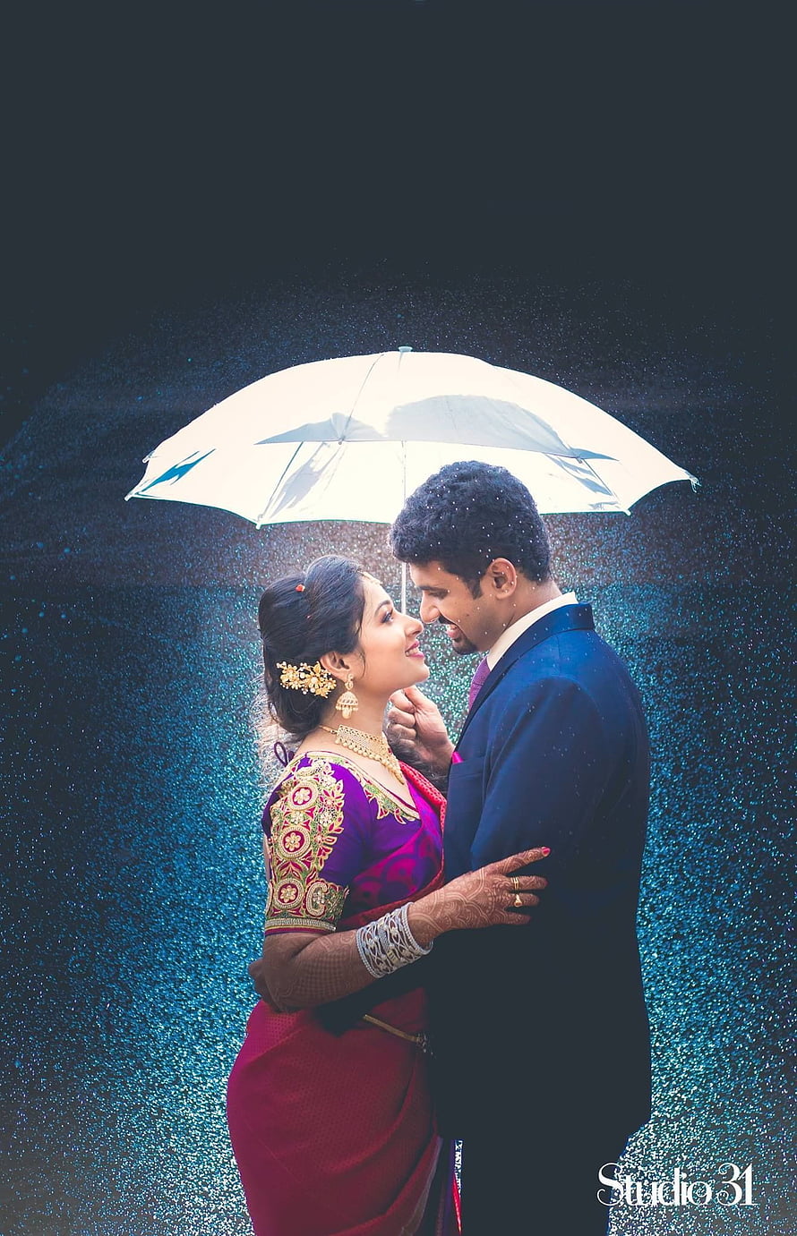 South Indian couple in traditional attire sharing a tender moment under a white umbrella in the rain HD phone wallpaper