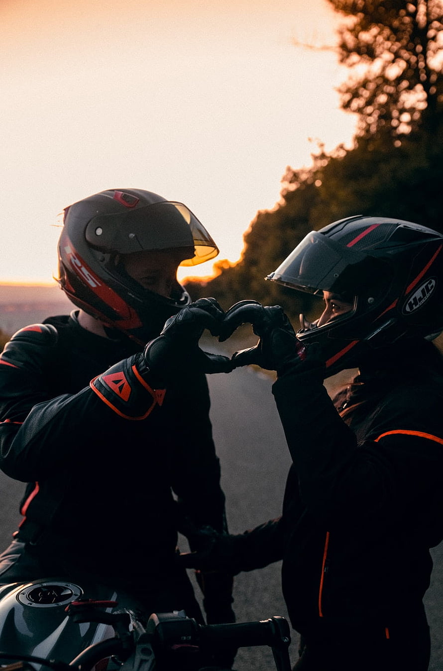 Biker Couple Forming Heart Shape With Gloves at Sunset HD phone wallpaper