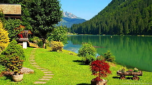 Serene Alpine Lake Landscape with Lush Green Garden and Mountain View HD wallpaper