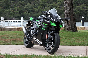 Kawasaki Ninja ZX-10R sportbike parked on a lakeside path with green and black livery HD wallpaper