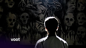 Silhouette of a person facing a dark wall covered in creepy skull and monster drawings HD wallpaper