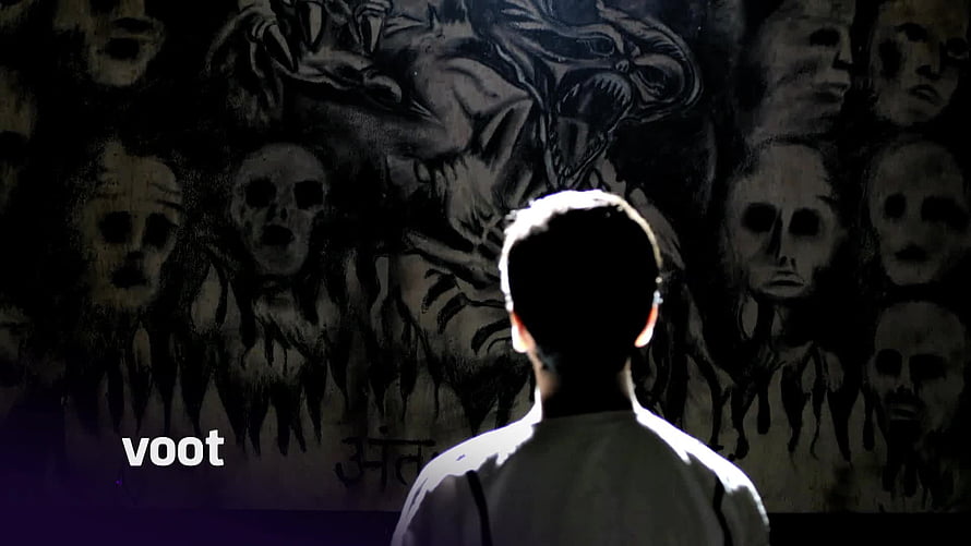 Silhouette of a person facing a dark wall covered in creepy skull and monster drawings HD wallpaper