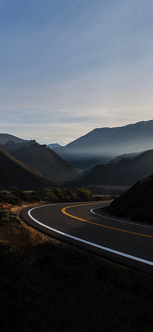 Winding Mountain Road Through Misty Valley at Dawn HD phone wallpaper