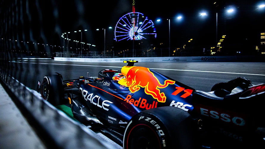 Red Bull Racing Formula 1 car on track at night with illuminated Ferris wheel in background HD wallpaper
