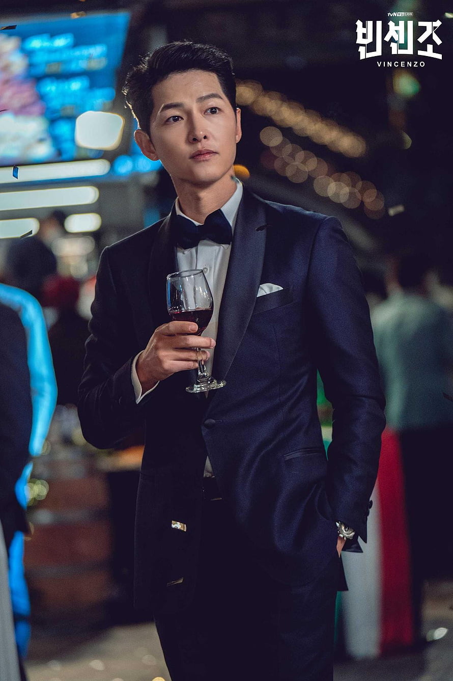 Song Joong Ki as Vincenzo Cassano in a tuxedo holding a glass of red wine at a formal event HD phone wallpaper