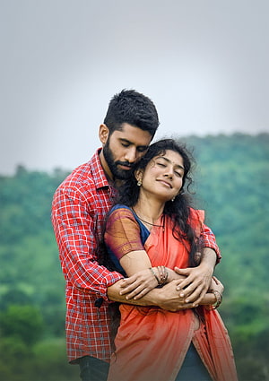 Romantic Indian couple embracing outdoors with lush green hills in the background HD phone wallpaper