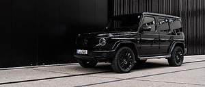 Black Mercedes-Benz G-Class SUV Parked Against Dark Modern Architecture HD wallpaper