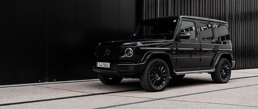 Black Mercedes-Benz G-Class SUV Parked Against Dark Modern Architecture HD wallpaper