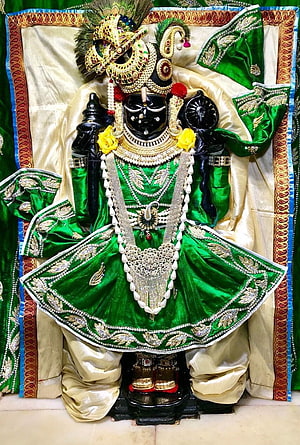 Ornate Dwarkadhish Krishna Idol in Green Silk Attire with Gold Jewelry and Peacock Crown HD phone wallpaper