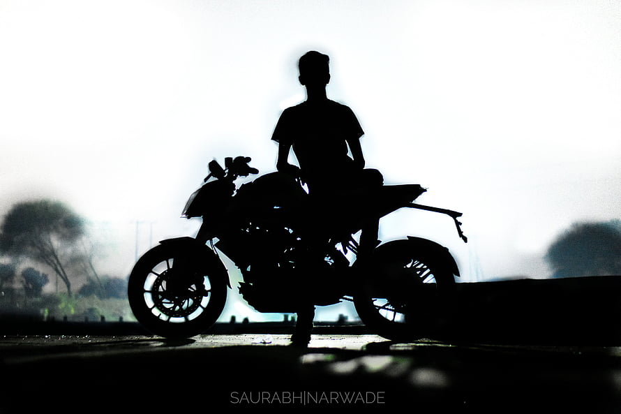 Silhouette of a Biker Sitting on a Motorcycle Against a Bright Hazy Background HD wallpaper