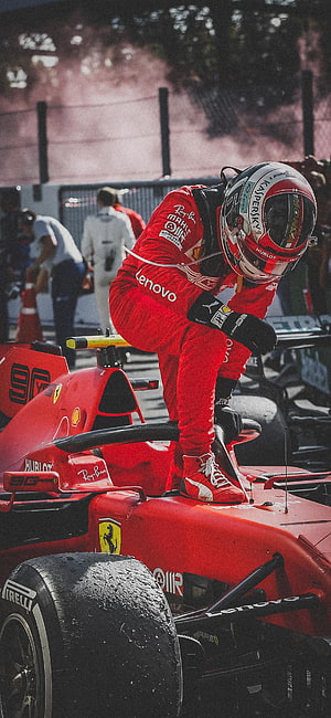 Charles Leclerc in Ferrari Red Racing Suit Climbing into F1 Car on Wet Track HD phone wallpaper