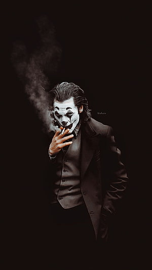 The Joker smoking a cigarette in a dark suit with white face paint and black makeup HD phone wallpaper