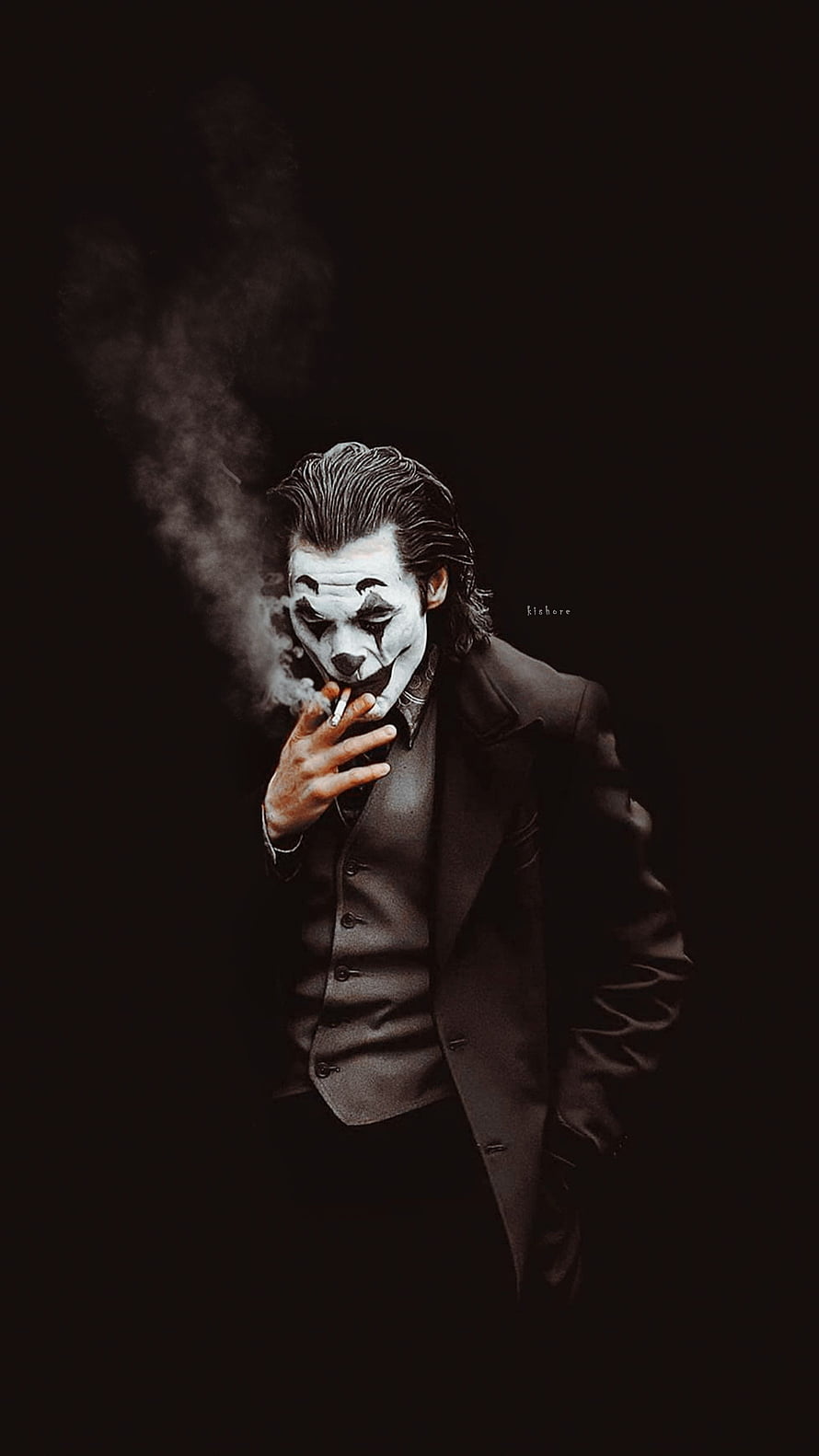The Joker smoking a cigarette in a dark suit with white face paint and black makeup HD phone wallpaper