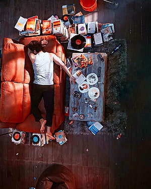 Overhead View of Man Sleeping on Orange Sofa Amidst Messy Room with Vinyl Records and Trash, Trending of Master movie Thalapathy Vijay sleeping, master thalapathy HD phone wallpaper