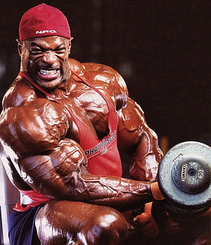 Ronnie Coleman performing intense dumbbell curls in red tank top and cap, Ronnie Coleman Group, ronnie coleman bodybuilding HD phone wallpaper