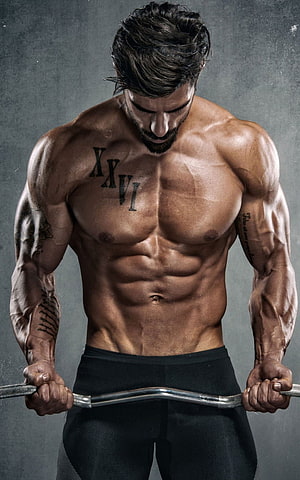 Muscular Male Bodybuilder Performing Barbell Curl With Defined Abs And Chest Tattoos HD phone wallpaper