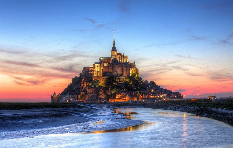 Mont Saint-Michel Abbey at Sunset with Tidal Flats and Warm Sky Reflections HD wallpaper