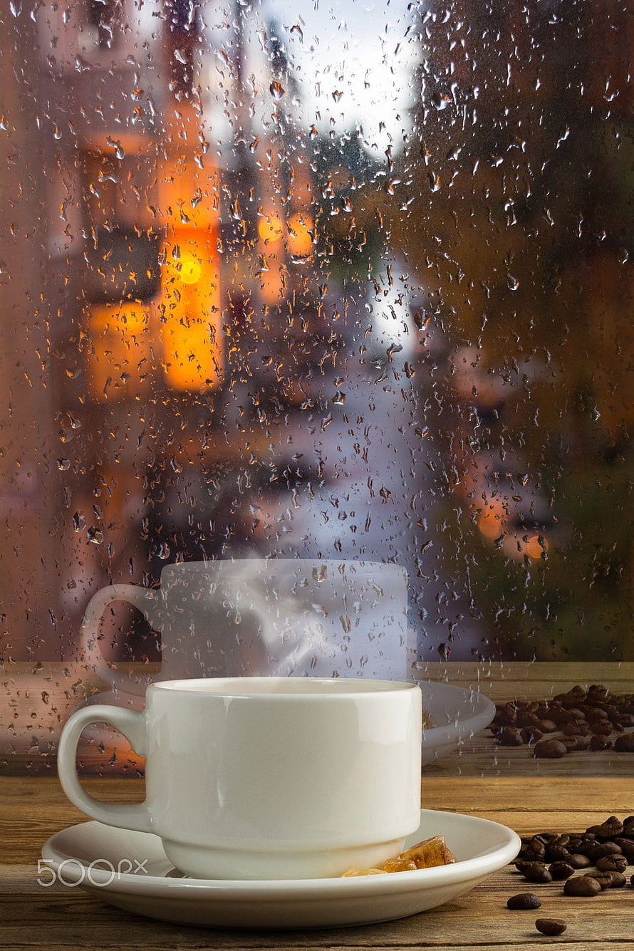 Steaming White Coffee Cup on Wooden Table Beside Rainy Window with Autumn City Lights HD phone wallpaper