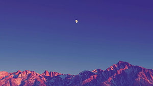 Pink Alpenglow Mountain Range Under Blue Sky With Crescent Moon HD wallpaper