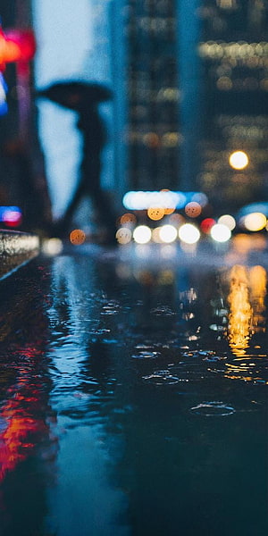 Moody Rainy City Street with Blurred Bokeh Lights and Wet Pavement Reflections HD phone wallpaper