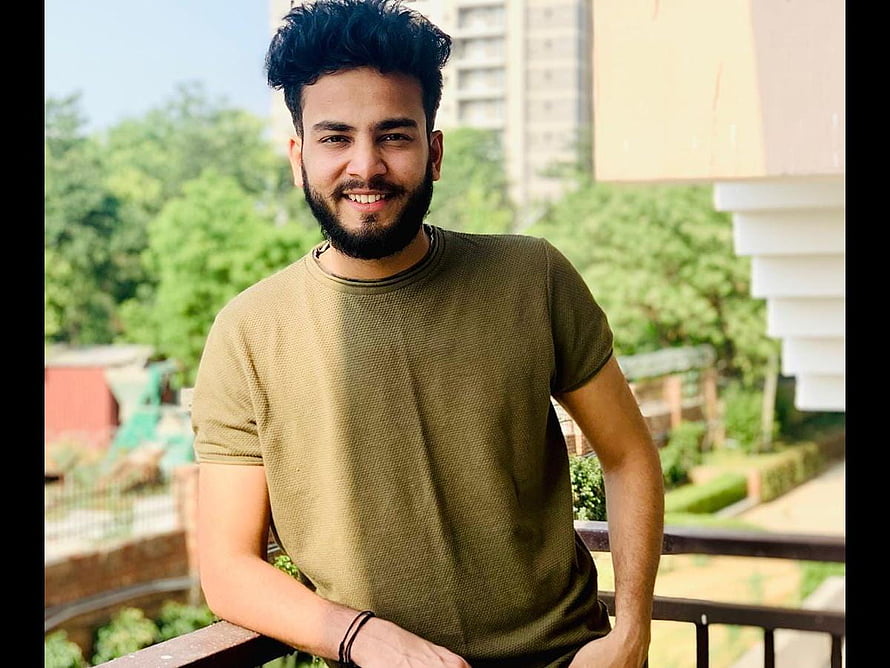Portrait of a smiling young man with a beard wearing an olive green t-shirt on a balcony, EXCLUSIVE: TikTok Vs YouTube: Elvish Yadav on YT removing Carry Minati's video, Aamir Siddiqui's roast HD wallpaper