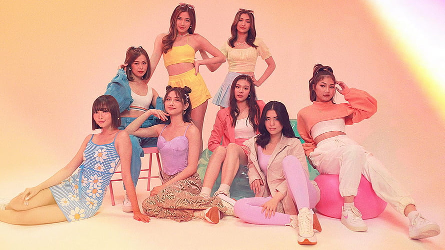 BNK48 members posing in colorful pastel outfits for a vibrant group photo shoot HD wallpaper