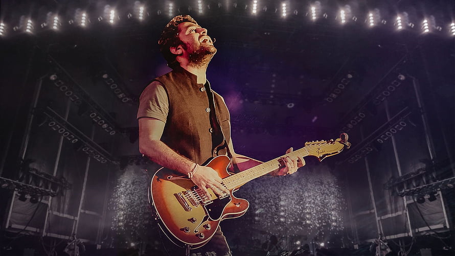 John Mayer performing live on stage with a sunburst electric guitar under dramatic concert lighting HD wallpaper