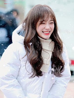 Kim Sejeong smiling in a white winter coat and cream scarf during a snowfall HD phone wallpaper