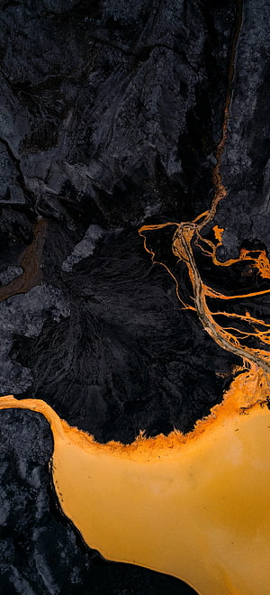 Aerial View of Golden River Delta Flowing Through Dark Volcanic Landscape HD phone wallpaper