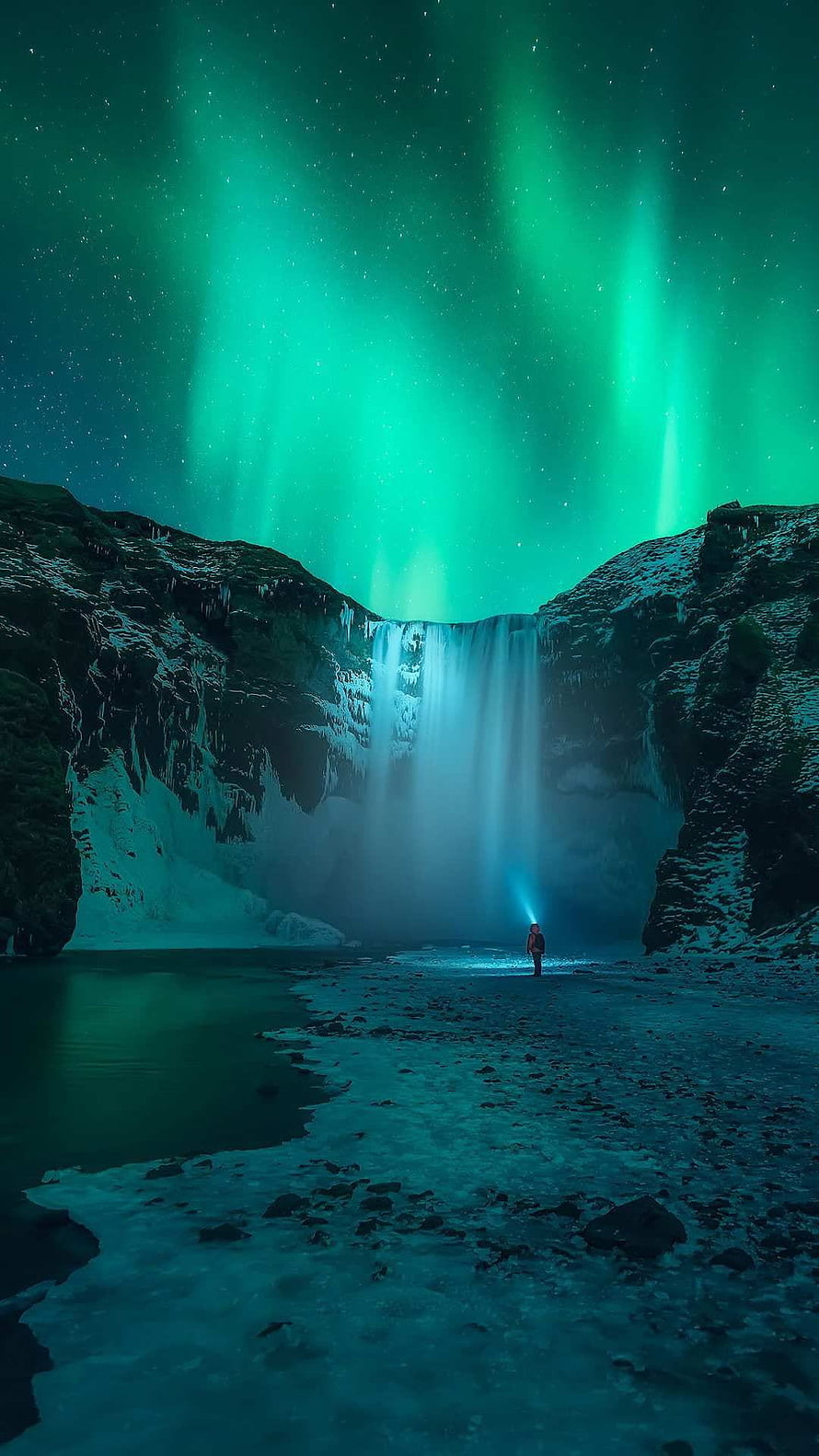 Icelandic Waterfall Under Vibrant Green Aurora Borealis with Lone Hiker HD phone wallpaper