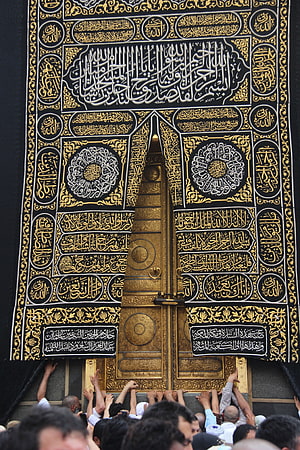 Ornate Golden Kaaba Door with Intricate Arabic Calligraphy and Pilgrims Reaching Toward the Sacred Entrance HD phone wallpaper