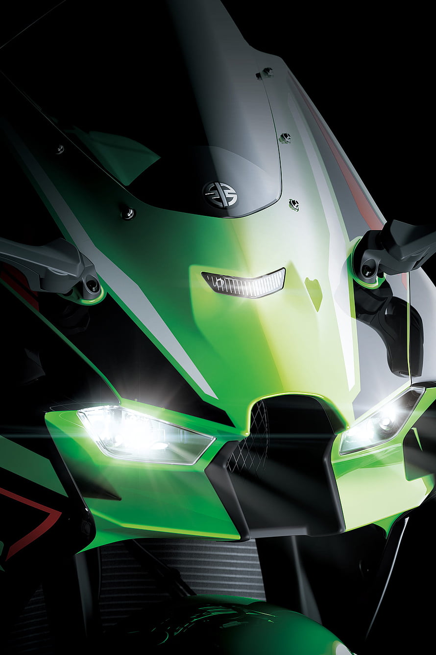 Close-up of a green Kawasaki Ninja motorcycle front fairing with bright headlights HD phone wallpaper