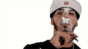 Portrait of a man exhaling smoke while holding a cigarette against a white background, Anuel AA HD wallpaper